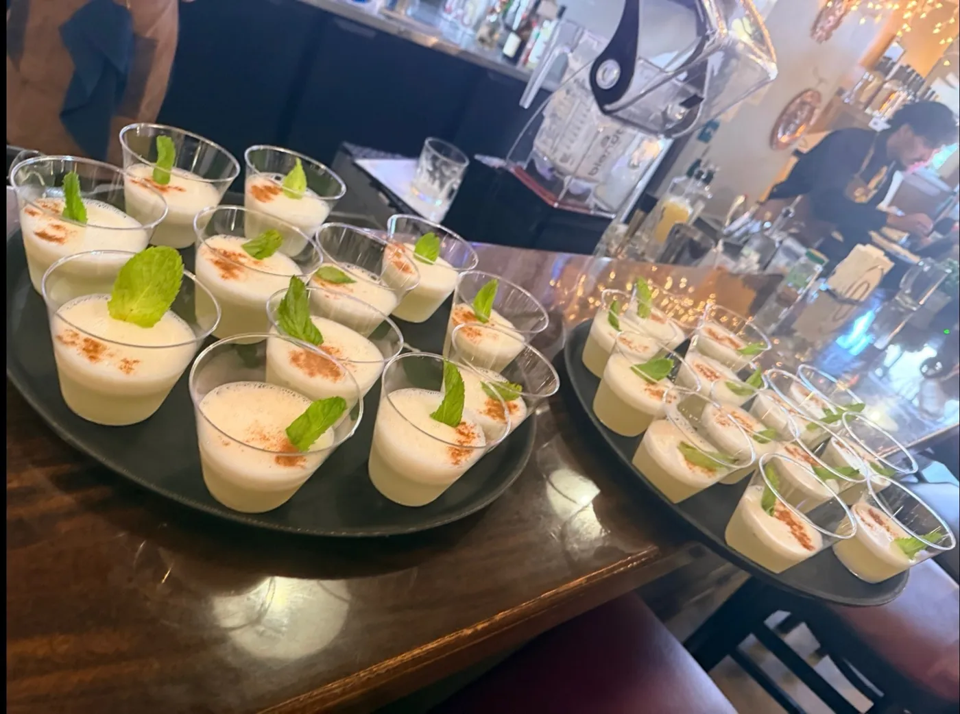 Trays of pisco sours with cinnamon and mint on the bar at Coya